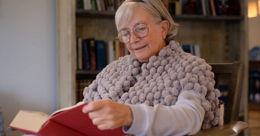 Elder woman reading how assisted living improves quality of life