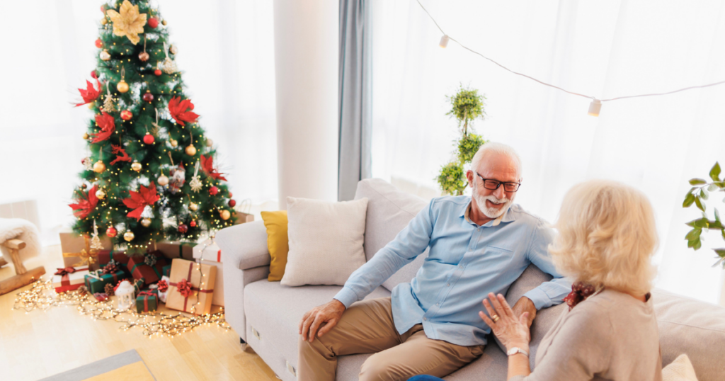 Senior couple on couch with tree in background during holiday stress