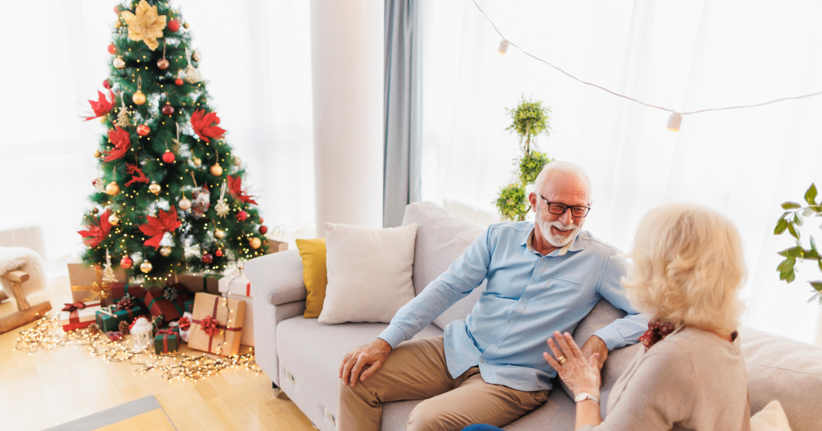 Senior couple on couch with tree in background during holiday stress